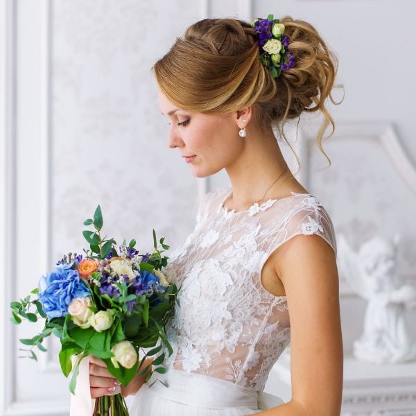side-profile-of-bride-in-white-dress-with-blue-bouquet-of-wedding-flowers