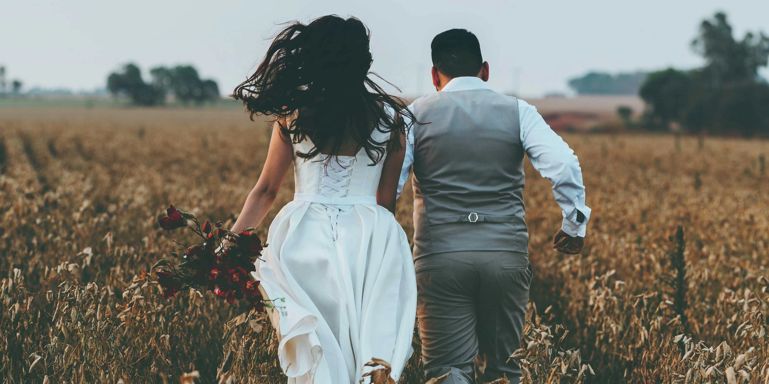 Wedding couple running in wheat field