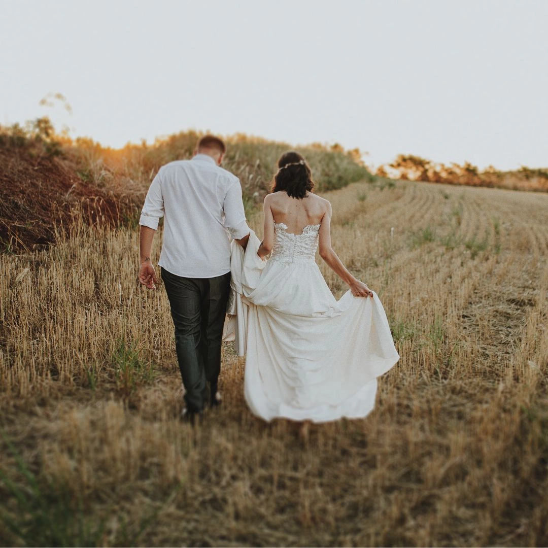 Couple walking in the field at sunset
