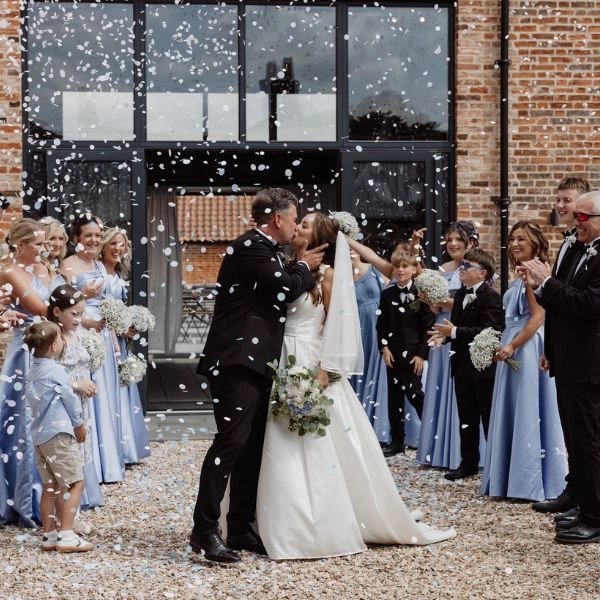 Confetti over couple at Thteford Farm Barn