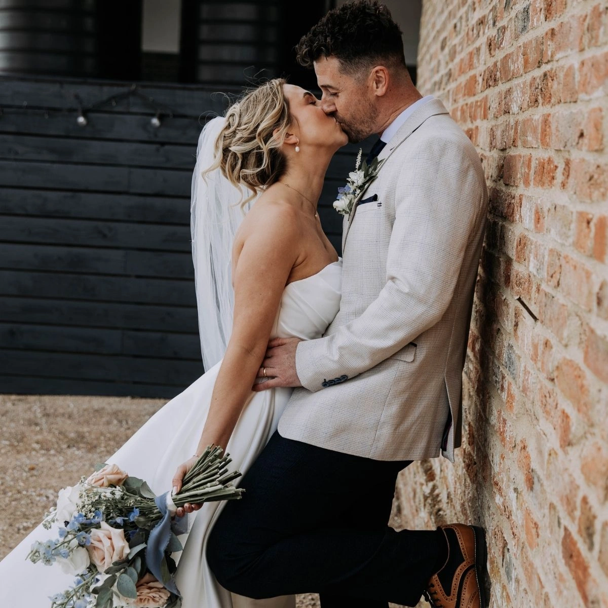 Bride and groom kissing in the courtyard